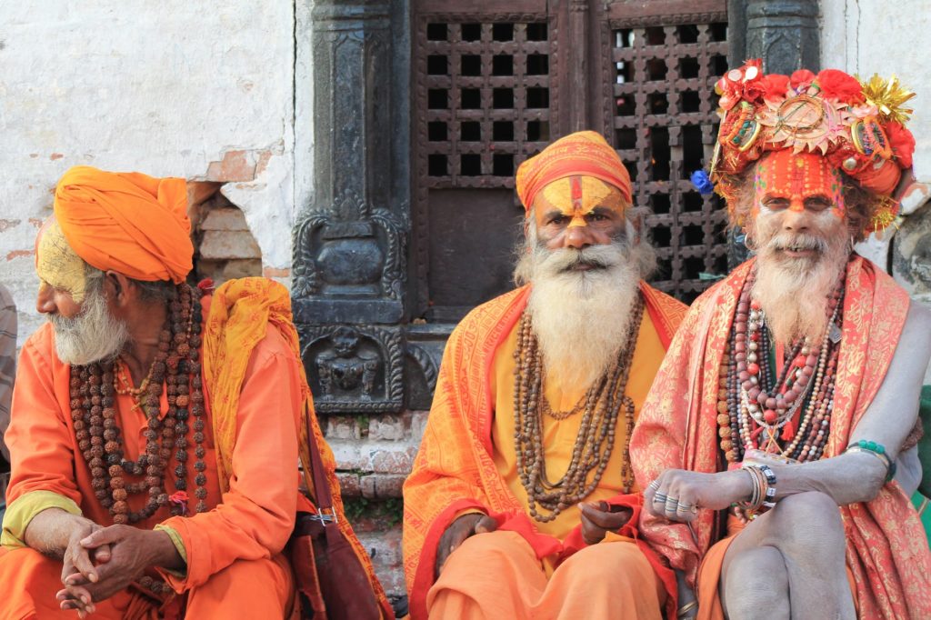 three men wearing orange tradition clothes