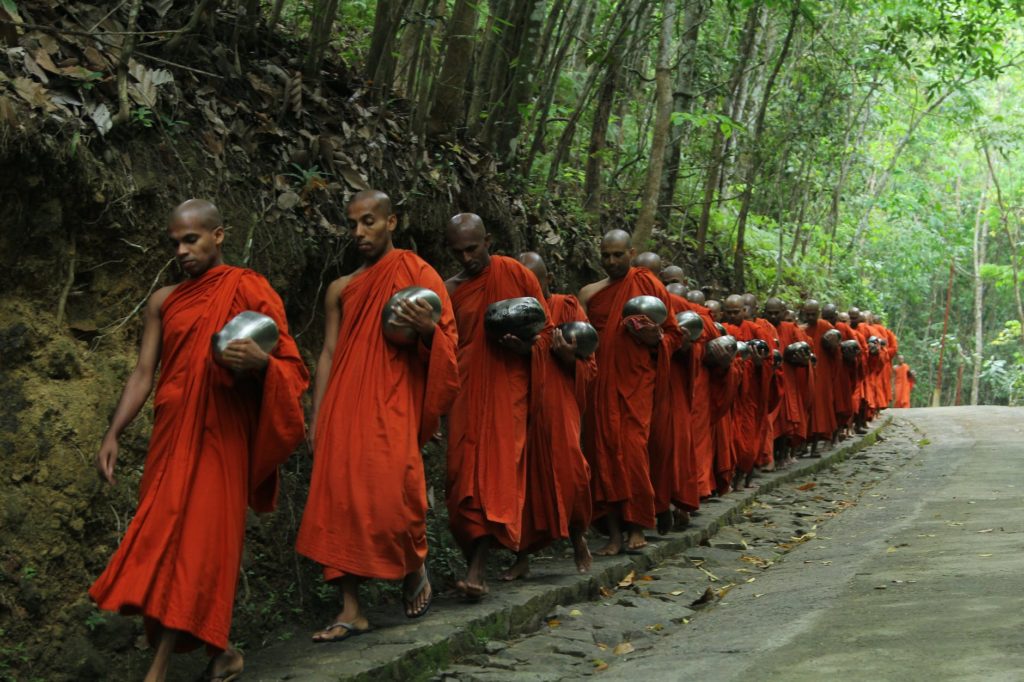 monks fall inline on sidewalk