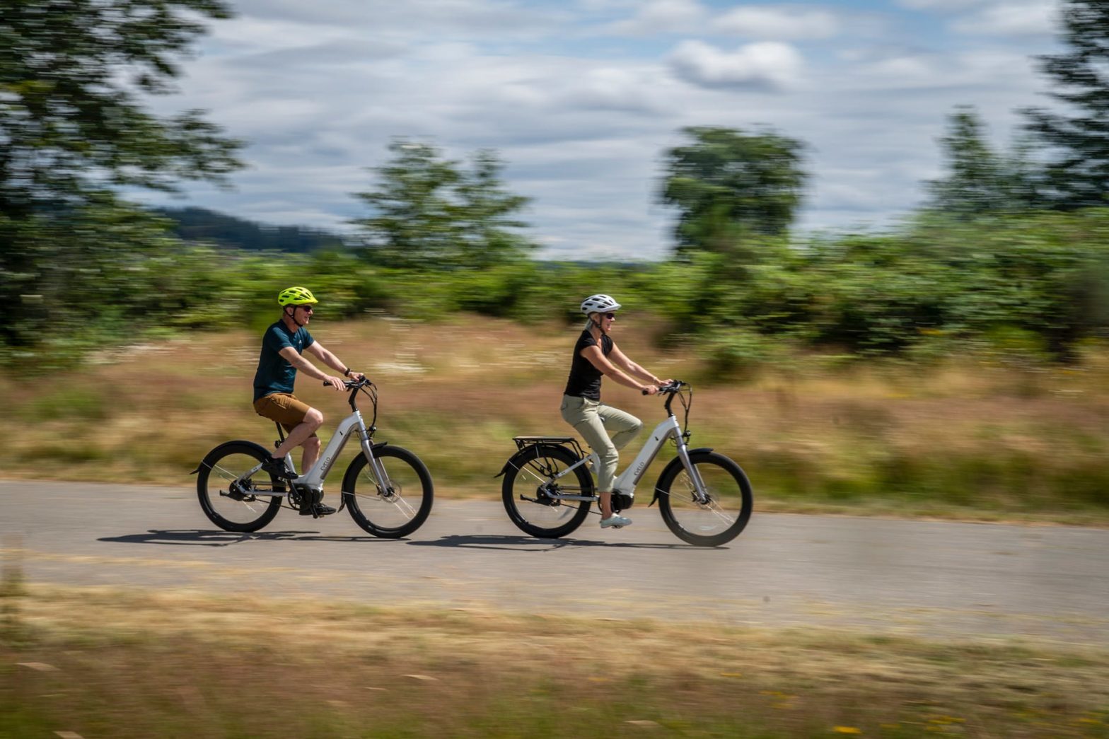 a couple bicycling fast on a rural road